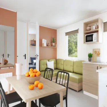 Mobil Home Aqua 3 Chambres 6/8 Personnes Clim TV - Domaine du Golfe de Saint-Tropez : salle à manger avec table et canapé vert