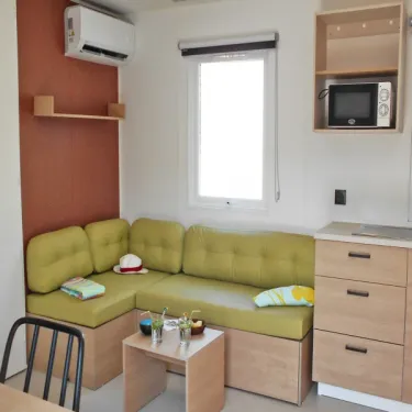Salon avec canapé et cuisine dans le Mobil Home, Domaine du Golfe de Saint-Tropez