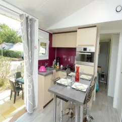Mobil Home Aqua 2 Chambres - cuisine ouverte avec table à manger, four, réfrigérateur, vue jardin