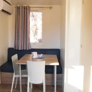 Mobil Home Aqua 3 Chambres 6 Personnes Terrasse Semi-Couverte Clim TV - Les cigales : coin repas avec table et canapé
