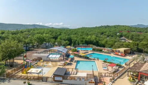 Piscine entourée d'un espace détente avec toboggan et jeux pour enfants au Camping Domaine de Chaussy.