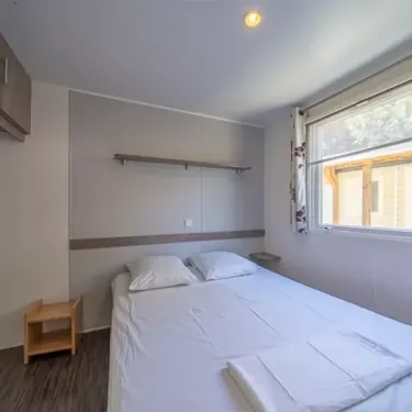 Chambre du Mobil Home Aqua 2 Chambres, lit double, literie blanche, étagères murales