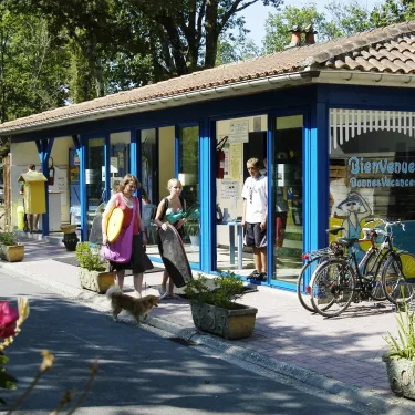 Photo camping Le Palace : boutique bleue avec vélos et chien