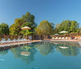 Piscine avec chaises longues et parasols au Camping Le Mas de Sireuil