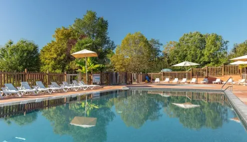 Piscine avec chaises longues et parasols au Camping Le Mas de Sireuil