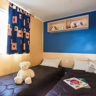 Chambre du Mobil Home Aqua 2 chambres à Le Mas de Sireuil, lit, ours, couverture