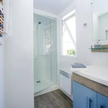 Salle de bain du Mobil Home Aqua 2 chambres à Le Mas de Sireuil, douche, lavabo, miroir
