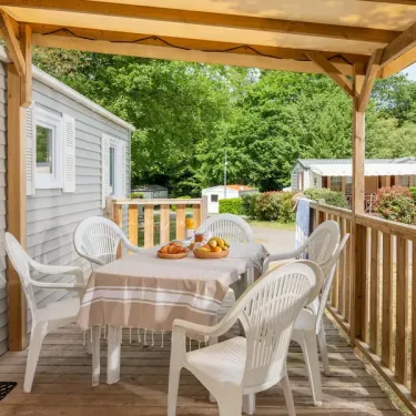 Terrasse semi-couverte avec table et chaises blanches