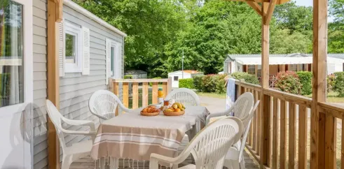 Terrasse semi-couverte avec table et chaises blanches