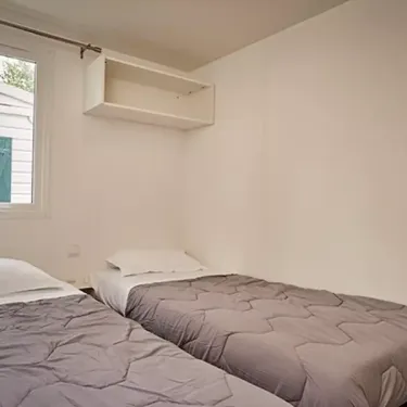 Chambre avec deux lits, étagère murale et fenêtre - Mobil Home Aqua 3 Chambres 6 Personnes Terrasse semi-couverte - Moulin de Kermaux