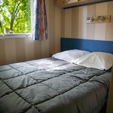 Lit double dans la chambre du Mobil Home Aqua