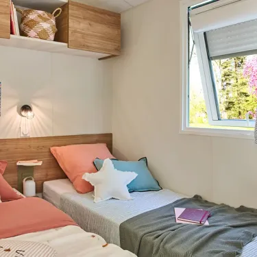 Chambre avec lits, couvre-lits et oreiller décoratif