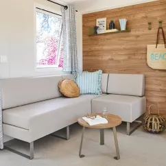 Mobil Home Aqua 2 Chambres - salon avec canapé, table et mur en bois