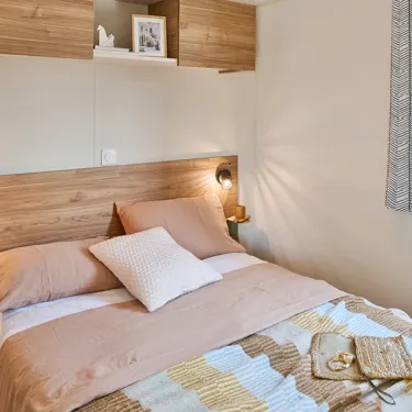 Mobil Home Aqua 2 Chambres - chambre avec lit, tête de lit en bois et éclairage
