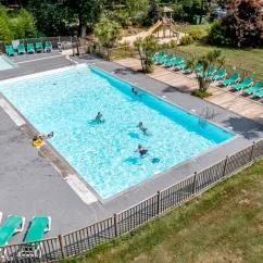 Piscine avec chaises longues et toboggan au Camping La Clairière