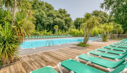 Piscine entourée de chaises longues vertes Camping La Clairière