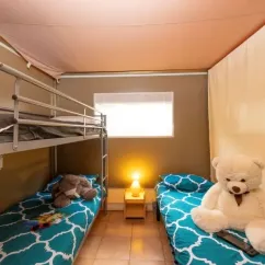 Chambre avec lits superposés et lit simple, ours en peluche, camping Le Lac des Sapins.