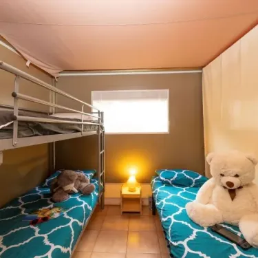 Chambre avec lits superposés et lit simple, ours en peluche, camping Le Lac des Sapins.