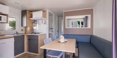 Salle à manger et cuisine du mobil home Le Paradis, canapé, table