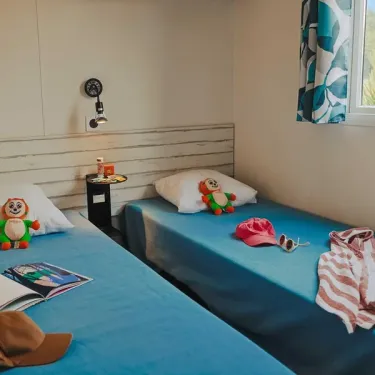 Chambre double avec lits bleus et jouets, Cottage Luxe 2 SDB - Camping Le Paradis
