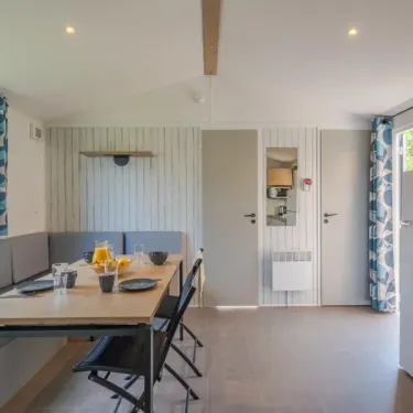 Salle à manger avec table, chaises et banc, Cottage Prestige - Camping Le Paradis