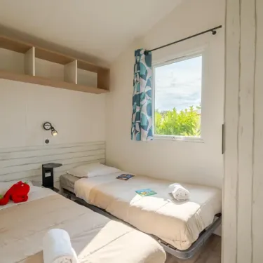 Chambre double avec lits, étagères murales, Camping Le Paradis