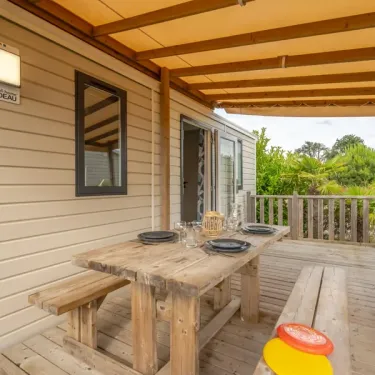 Terrasse en bois avec table et banc, Cottage Prestige, Camping Le Paradis