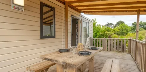 Terrasse en bois avec table et banc, Cottage Prestige, Camping Le Paradis