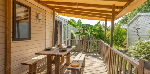 Terrasse en bois avec table et bancs - Cottage Prestige 3CH - 6P - Camping Le Paradis