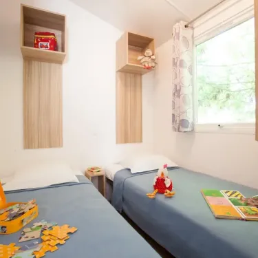 Chambre de Cottage Confort 3CH - 6P - Camping Le Paradis avec lits et étagères