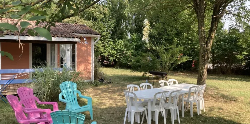 Chalet 2CH - 7P - Village Vacances Le Hameau des Genêts : jardin avec chaises et table