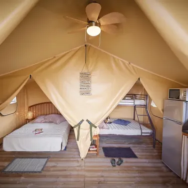 Intérieur du bungalow Toilé Bali avec lits, climatiseur et frigo