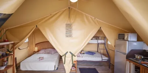 Intérieur du bungalow Toilé Bali avec lits, climatiseur et frigo