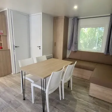 Mobil Home Confort 2 Chambres 4 Personnes TV - Le Domaine du Bois Coquet : salle à manger avec table et chaises