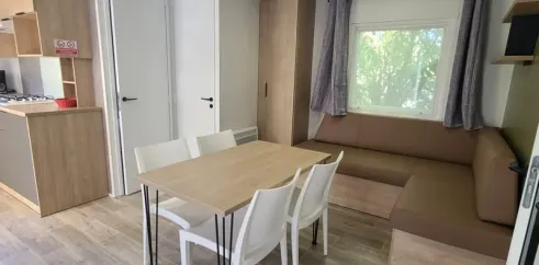Mobil Home Confort 2 Chambres 4 Personnes TV - Le Domaine du Bois Coquet : salle à manger avec table et chaises