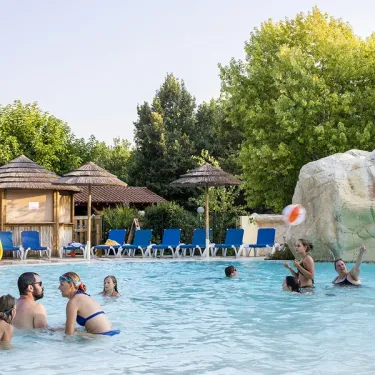 Famille qui joue dans la piscine avec une boule à l’Évasion