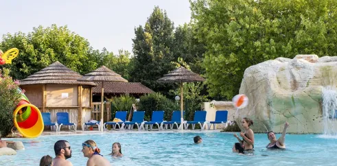 Famille qui joue dans la piscine avec une boule à l’Évasion