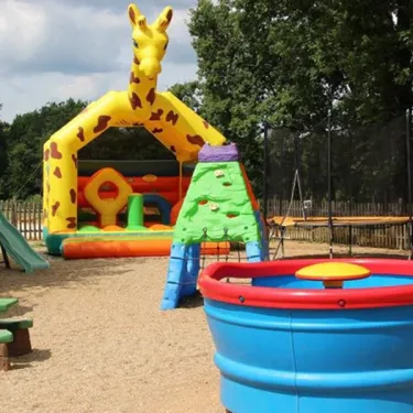 Camping l’Évasion : aire de jeux enfants avec girafe gonflable, piscine et toboggan