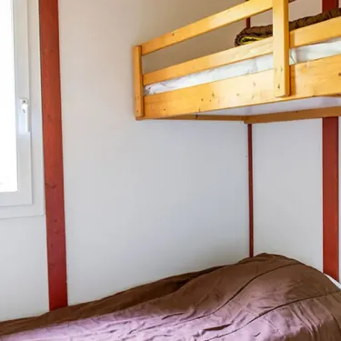 Chambre avec lit superposé en bois dans le chalet Camping l'Évasion