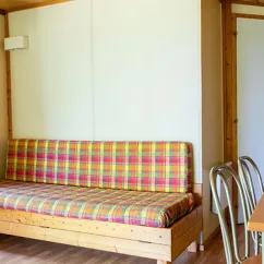 Canapé dans chalet Puy l'Evêque 3 chambres 7/9 personnes Camping l'Évasion avec chaises en bois