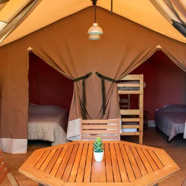 Tente Lodge 2 Chambres 5 Personnes Sans sanitaires - Camping l'Évasion : intérieur avec lits, table et chaises