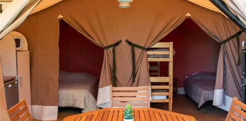 Tente Lodge 2 Chambres 5 Personnes Sans sanitaires - Camping l'Évasion : intérieur avec lits, table et chaises