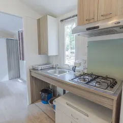Cuisine du mobil home Hélios avec plan de travail, four, évier et placards.