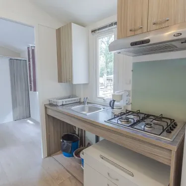 Cuisine du mobil home Hélios avec plan de travail, four, évier et placards.