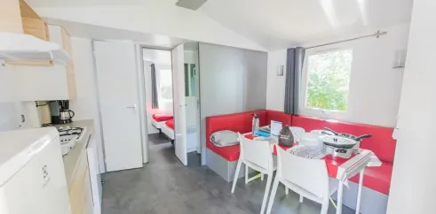 Salon du Mobil Home Premium 2 Chambres 4 Personnes et 1 Bébé - La Ferme avec canapé et table à manger