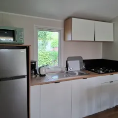 Cuisine du mobil home L'Orchis des Marais, avec frigo, four, et plan de travail