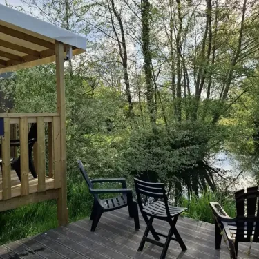 Terrasse en bois avec chaises près d'un lac, Mobil Home Le Trèfle d'Eau, Le Grand Pré