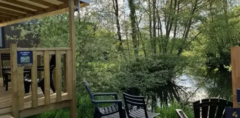 Terrasse en bois avec chaises près d'un lac, Mobil Home Le Trèfle d'Eau, Le Grand Pré