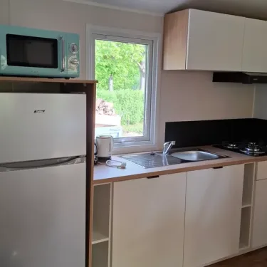 Cuisine avec réfrigérateur, micro-ondes et plan de travail - Mobil Home Le Trèfle d'Eau