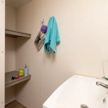 Mobil Home Confort 3 Chambres 6 personnes - Camping Paradis L'Europe, salle de bain avec baignoire et étagères